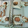 Four babies, one clearly affected by Dioxin, sleep at Go Vap orphanage.