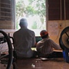 Two young men work at a lathe at a workshop in a rural training facility for victims of Dioxin.