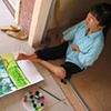 Sum, a residant of a training facility outside of Ho Chi Minh City specifically designed for persons effected by Dioxin, is an artist that paints with her feet.