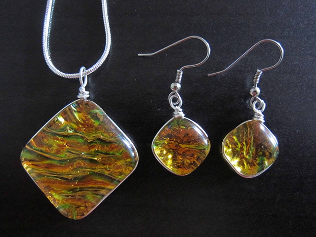 "Pillow" set in dark amber
details:
silver-wire wrapped pendant and earrings.
necklace: 1 1/4" wide, comes on 18" silver snake chain
earrings: approx. 5/8" wide
$60 necklace
$38 earrings
$98 for the Set