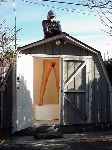 Sculpture of a twice life size woman, the upper half dressed and the lower half nude in a small gallery space