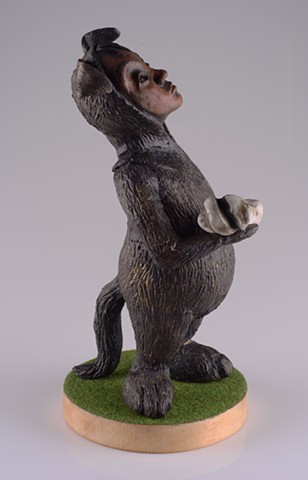 Child dressed in a dog 'onesie' with an expression of vexation as he holds up a large bone for inspection.