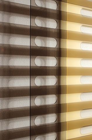 Geometric brown and yellow laser-cut acrylic sheet with spacers.