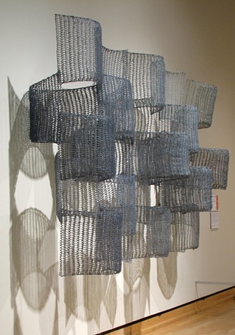 Organic geometric grid crocheted fiberglass and polyester resin wall sculpture based on Pi by Yvette Kaiser Smith