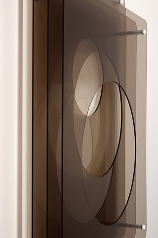 Brown and white laser-cut acrylic geometric abstraction.