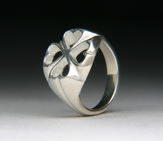 Four leaf clover or four hearts, maybe a flower.